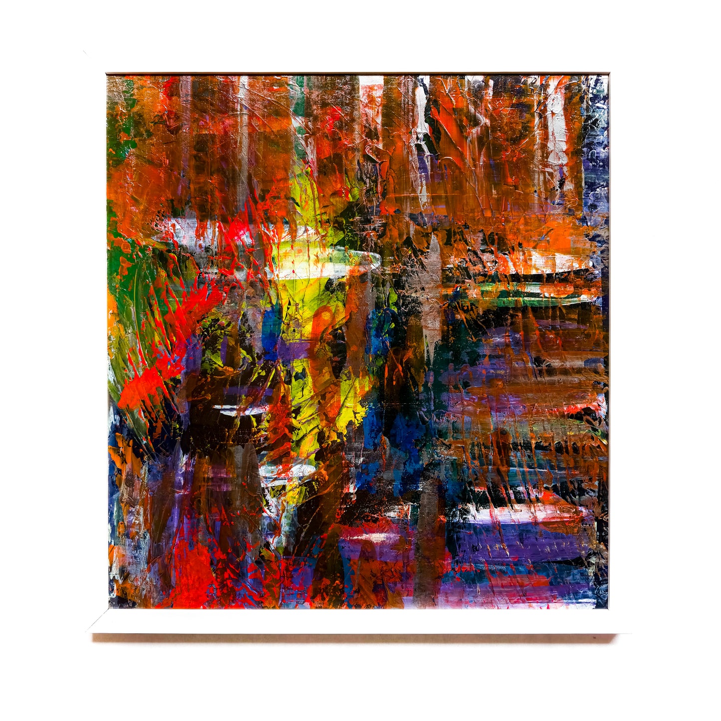 A framed abstract painting featuring a variety of dark and bright colors, with no discernible figures or shapes, primarily in a black, blue, red, and white palette.