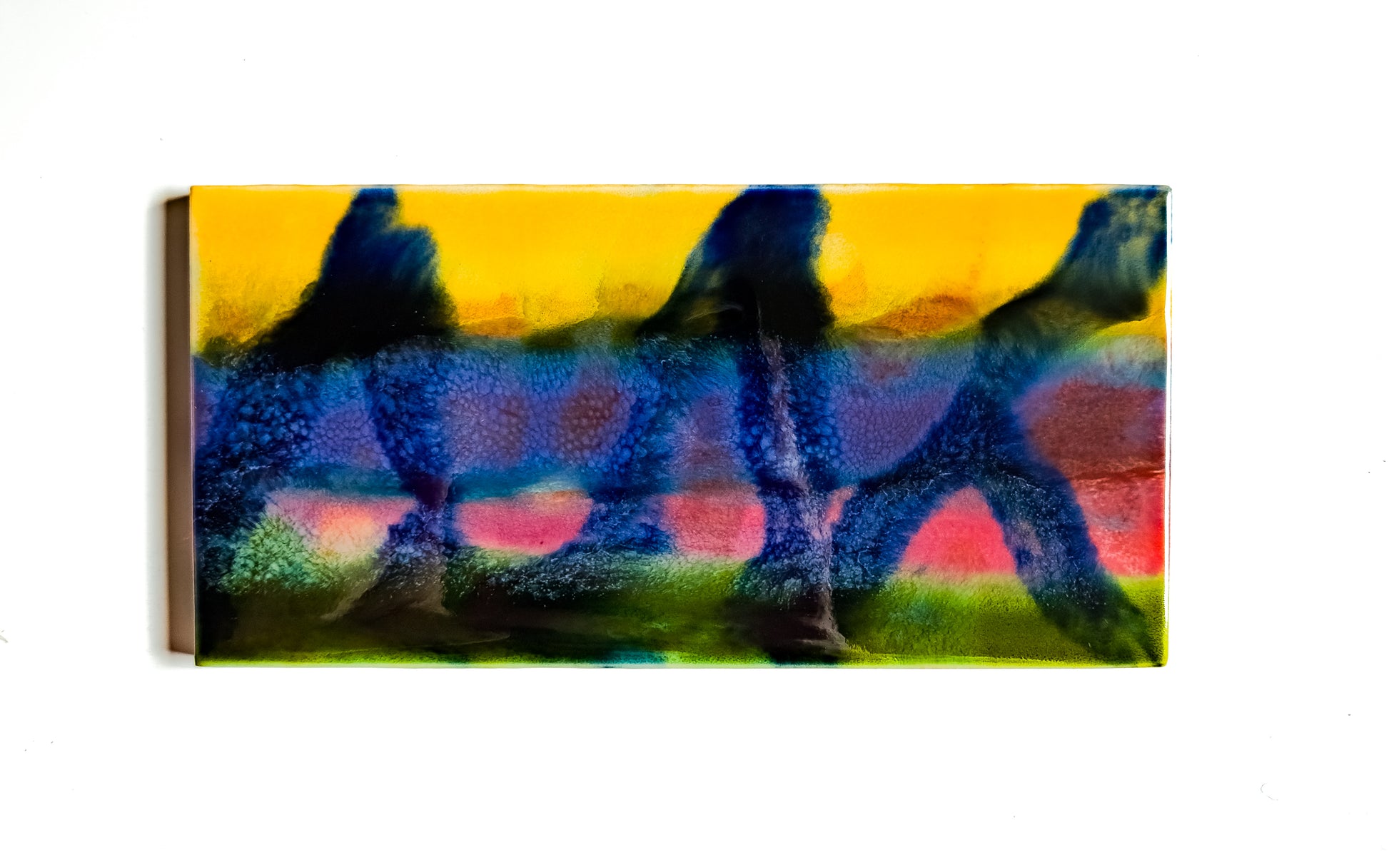This image features a unique glazed ceramic artwork titled "Attempt One." The artwork, measuring 3x6 inches, showcases an abstract composition in a vibrant array of colors.