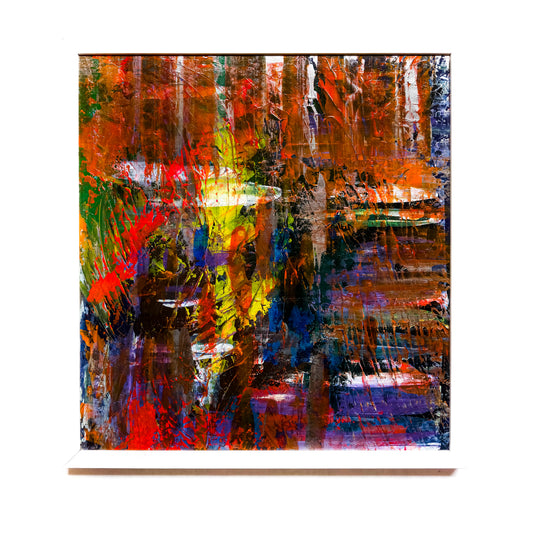 A framed abstract painting featuring a variety of dark and bright colors, with no discernible figures or shapes, primarily in a black, blue, red, and white palette.