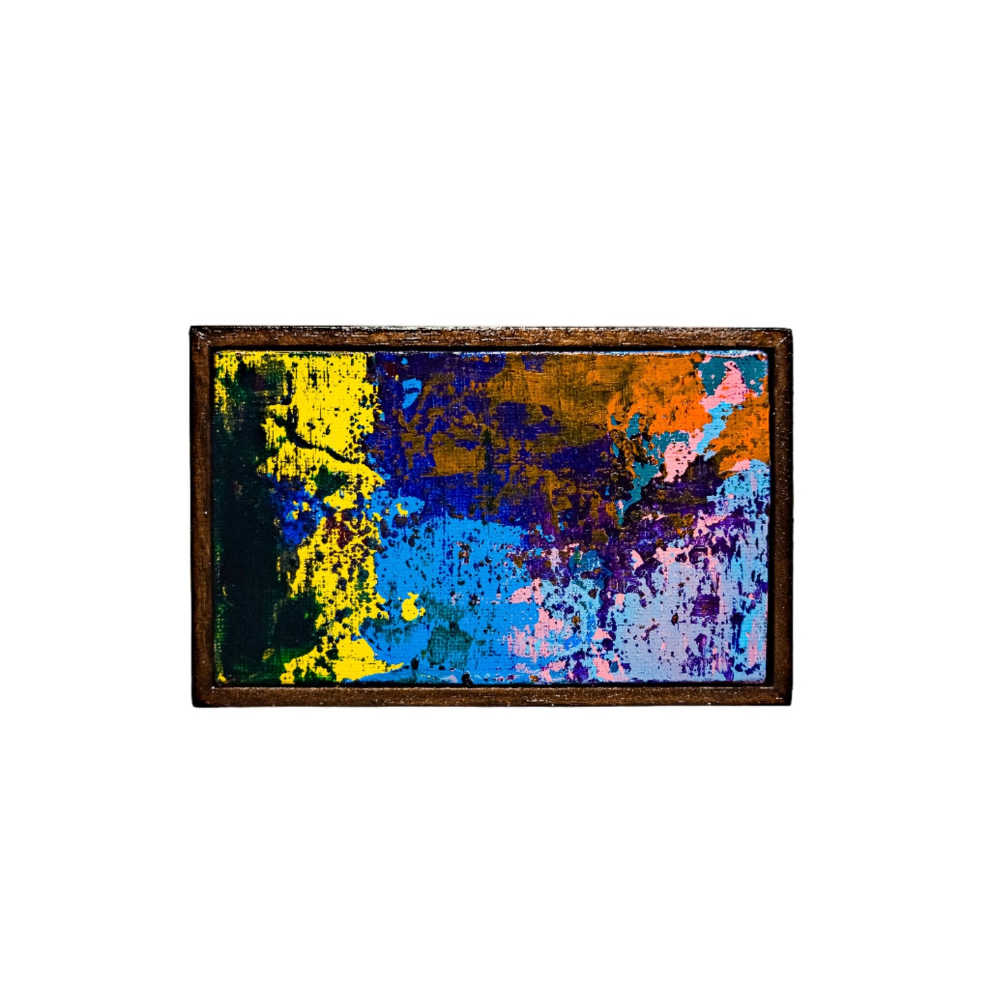 Abstract painting with colorful splashes in a wooden frame on a white wall