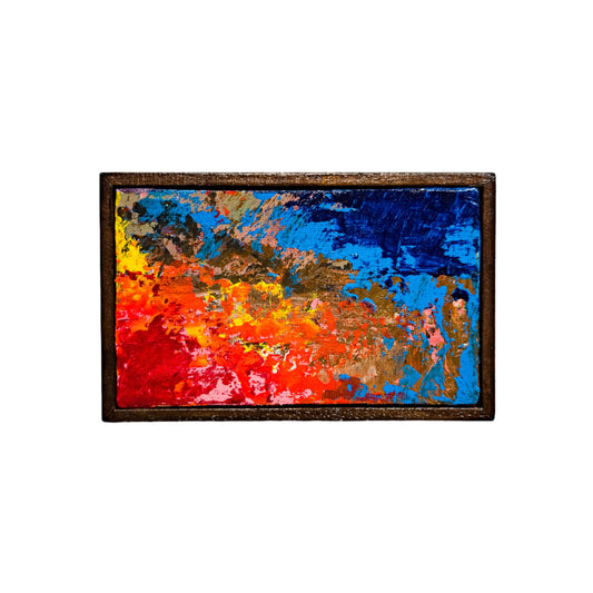 Abstract painting with vibrant colors in a wooden frame on a white background