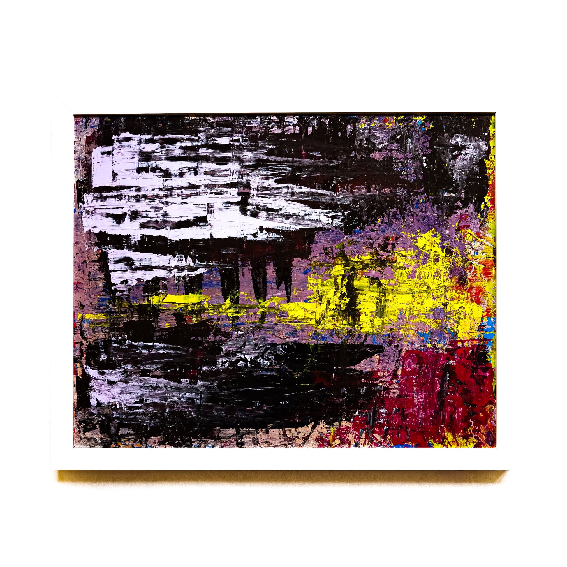 Abstract painting with black, yellow, and red on a white wall